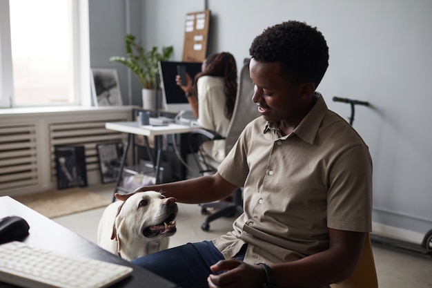 A woman playing with her cute dog while checking her phone